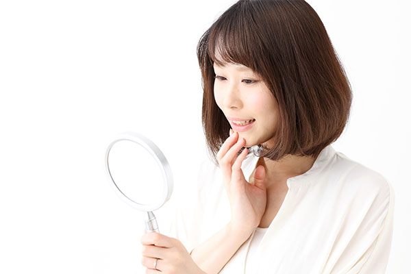 歯の黄ばみを鏡で確認する女性